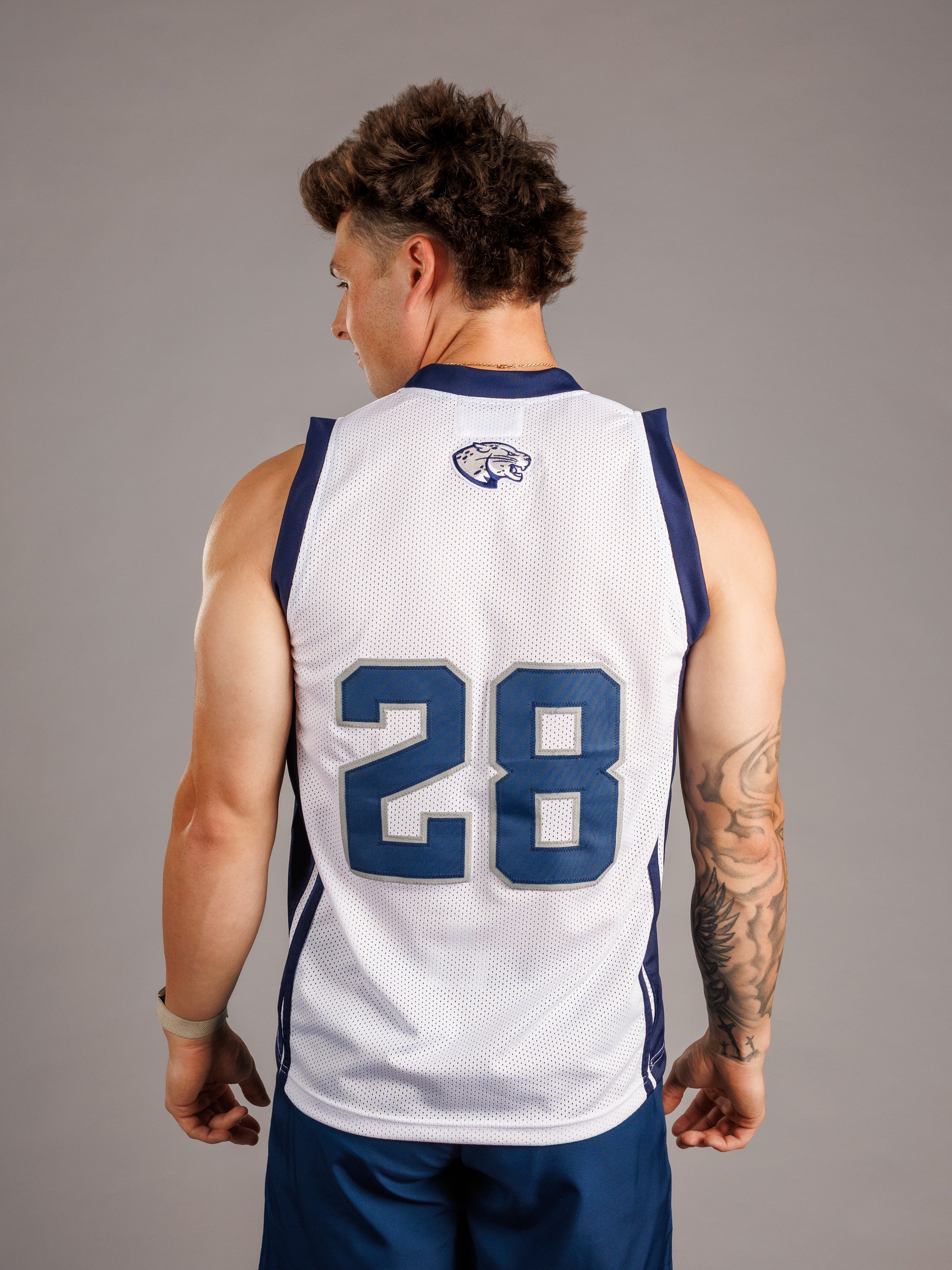 Augusta University men's basketball jersey by Arena Graffiti, navy blue with university logo and number 28, on display.