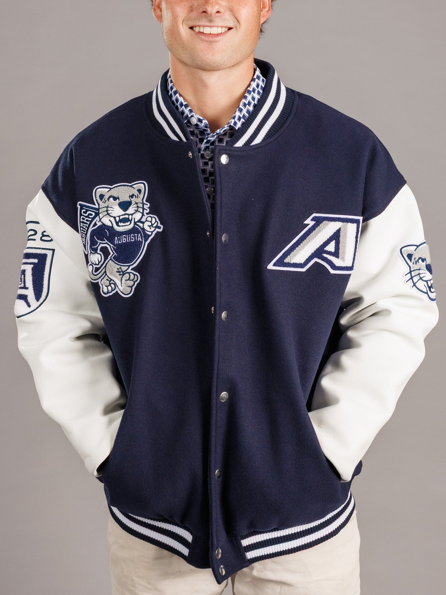 Arena Graffiti Augusta University men's varsity jag letterman jacket with university emblem and striped cuffs, front view.