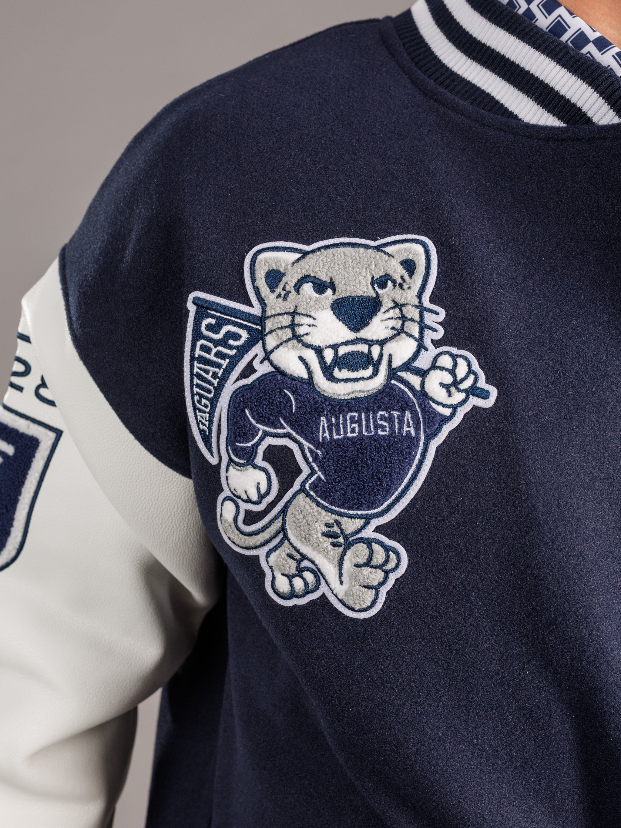 Men's varsity letterman jacket with Augusta University emblem by Arena Graffiti, featuring a wool body and leather sleeves.