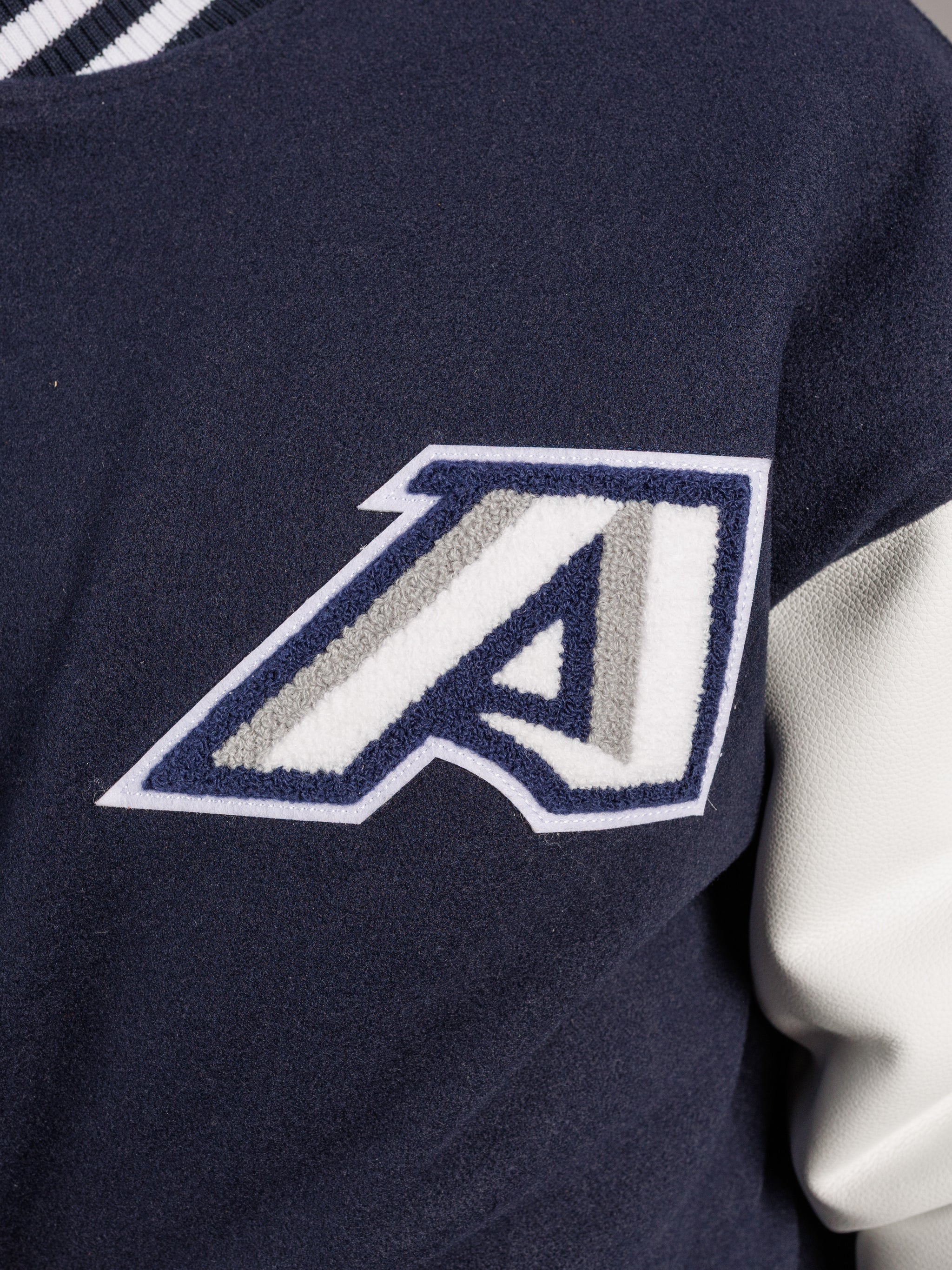 Arena Graffiti Augusta University men's varsity Jag letterman jacket with university crest and striped cuffs, front view.