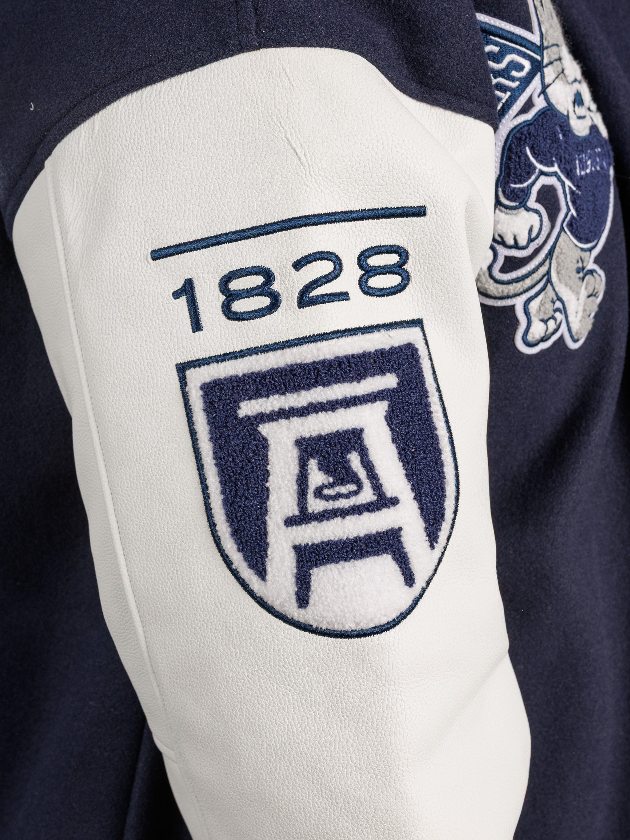 Augusta University men's varsity letterman jacket by Arena Graffiti, navy blue with university logo and letter patches.
