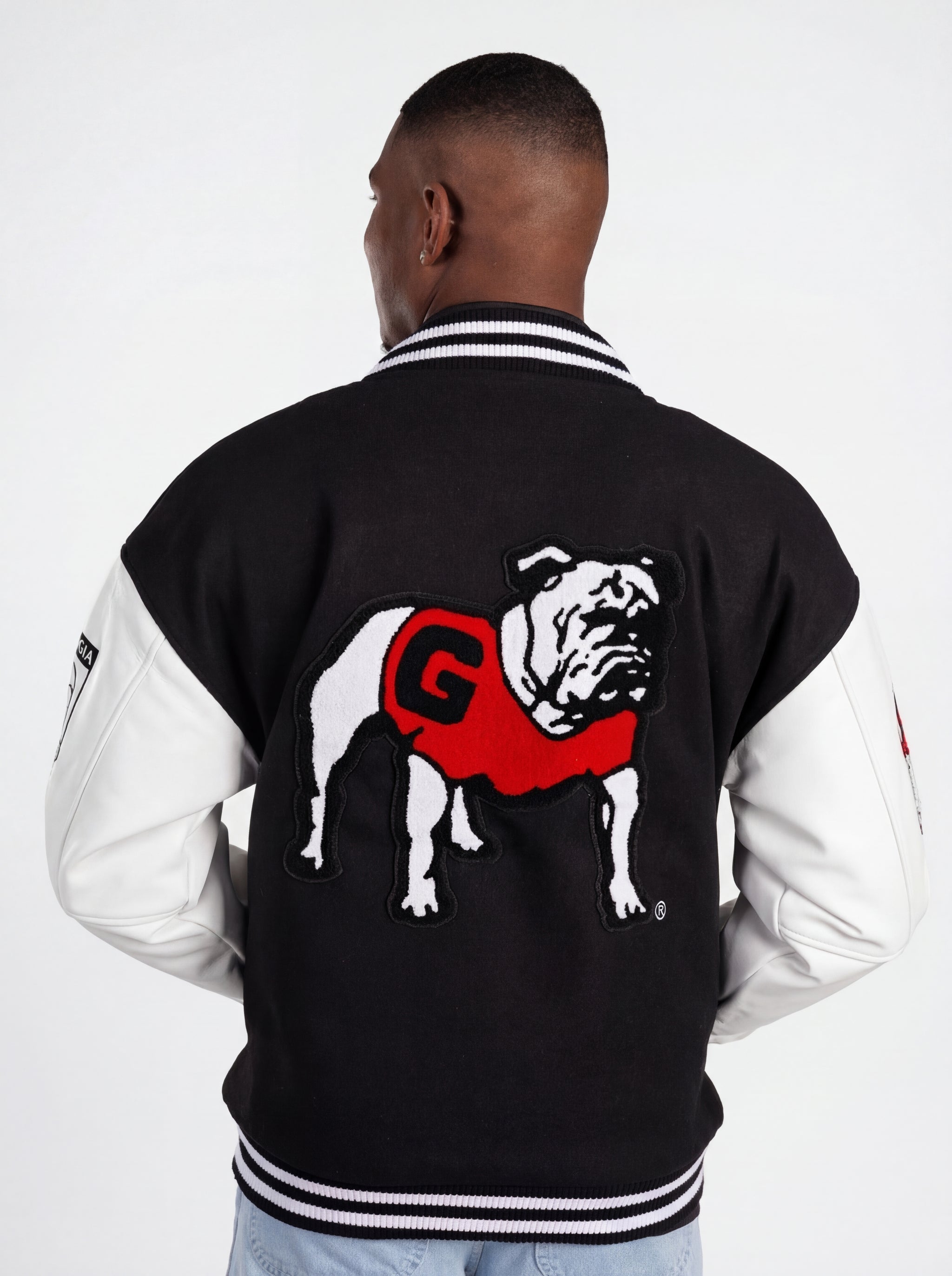UGA Bulldogs men's "Iron Varsity" letterman jacket by Arena Graffiti, featuring navy blue fabric, varsity patches, and letter embroidery.